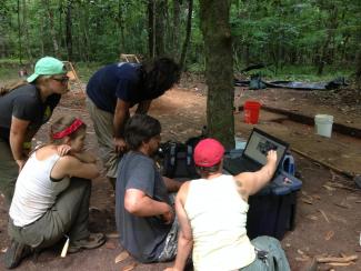 Archaeology students analyse data.